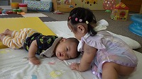 寝転がっている男の子とそれを見守る女の子