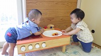 向かい合って笑いあう赤ちゃん2人