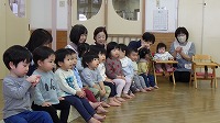 保育士の話を聞いている子ども