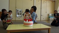 ケーキに飾りつけをしているお誕生児