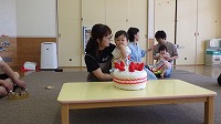ケーキに飾りつけをしているお誕生児