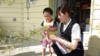 笹飾りをする男の子とお母さん