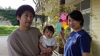 笹飾りの前で笑顔のお父さん、女の子、お母さん