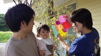 笹飾りをするお父さん、女の子、お母さん