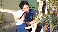 笹飾りをするお父さんと女の子