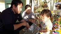 笹飾りをするお父さんと、お母さんと、男の子