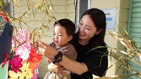 笹飾りをする男の子とお母さん