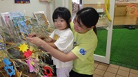 笹飾りをする女の子とお母さん