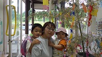 笹飾りの前で笑顔のお兄さんとお母さんと女の子