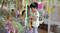 笹飾りをする男の子とお母さんとお姉さん