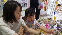 笹飾りをするお母さんと女の子