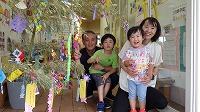 笹飾りの前で笑顔のお父さんとお兄さんと女の子とお母さん