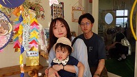 笹飾りの前で笑顔のお母さんと女の子とお父さん
