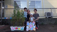 花の前でお兄さんお父さんお母さん女の子