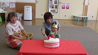 誕生日ケーキクッションに飾りつけしている誕生児