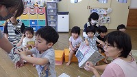 新聞紙を丸めて楽しんでいる子ども