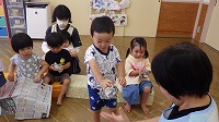 新聞紙を丸めて楽しんでいる子ども
