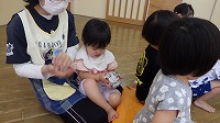 新聞紙を丸めて楽しんでいる子ども