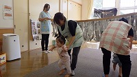 新聞紙カーテンをくぐり抜けて楽しんでいる子ども