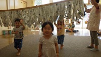新聞紙カーテンをくぐり抜けて楽しんでいる子ども