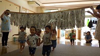 新聞紙カーテンをくぐり抜けて楽しんでいる子ども
