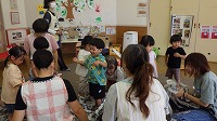 新聞紙の感触を楽しんでいる子ども達