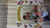 お母さんと一緒に記念撮影をしている誕生児