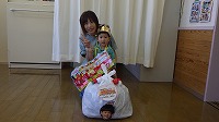 お母さんと一緒に記念撮影をしている誕生児