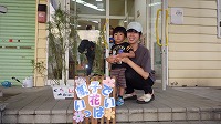 花の前で男の子とお母さん