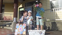 花の前で男の子とお母さんお兄さん