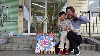 花の前でお母さんに抱っこされる女の子