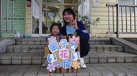 花の前で笑顔の女の子とお母さん