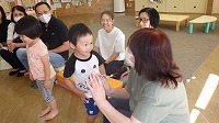 おばあさんとふれあい遊びを楽しんでいる子どもたち